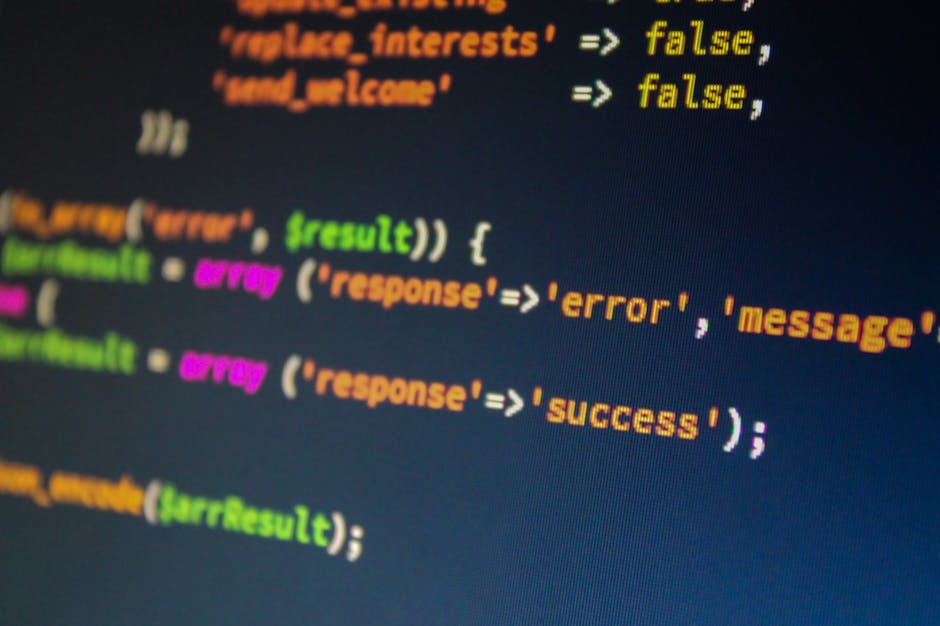 Photograph of a computer screen displaying HTML code with multiple nested tags and attributes in various colors, including pink, green, yellow, and white, indicating a web page's navigation menu and s